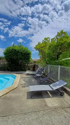 a group of lounge chairs next to a swimming pool at Canta aoussel in Moussoulens