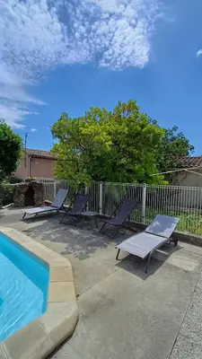 a group of lounge chairs and a swimming pool at Canta aoussel in Moussoulens