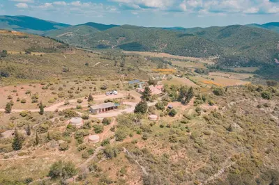 an aerial view of a house on a hill with mountains at Yourte Mongole Insolite - Gîte Saint Roch in Tuchan