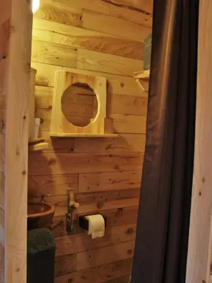 a bathroom with a wooden wall with a sink at Cabane Écureuil & Cabane Chevreuil in Fournes-Cabardès