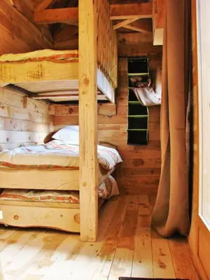 a bedroom with two bunk beds in a log cabin at Cabane Écureuil & Cabane Chevreuil in Fournes-Cabardès