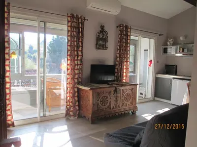 a living room with a wooden table and sliding glass doors at Maison TOMAS in Pomas