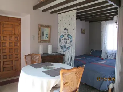 a bedroom with a table and a bed and a door at Maison TOMAS in Pomas