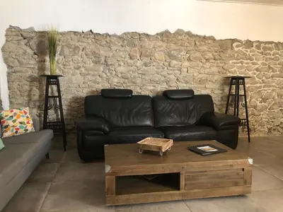 a living room with a leather couch and a coffee table at Coté remparts in Carcassonne