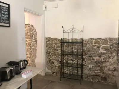 a room with a stone wall and a shelf at Coté remparts in Carcassonne