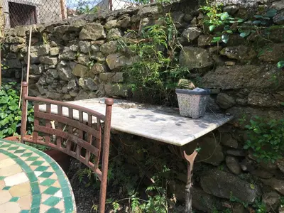 a wooden bench sitting next to a stone wall at Coté remparts in Carcassonne