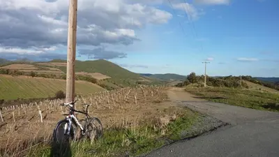 a bike parked next to a pole on the side of a road at L'Esprit du vallon de Berlou in Berlou