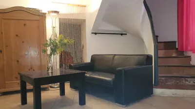 a living room with a leather chair and a table at L'Esprit du vallon de Berlou in Berlou