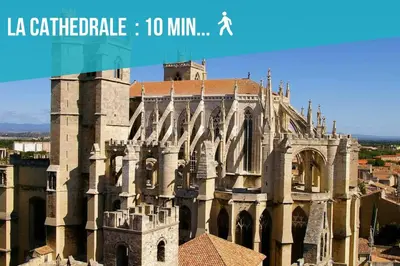 a large stone building with a clock tower at La Maisonnette Narbonnaise (Proche Grands Buffets) in Narbonne
