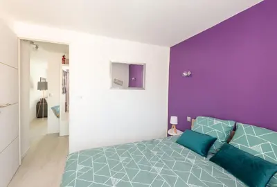 a bedroom with a bed with a purple wall at La Maisonnette Narbonnaise (Proche Grands Buffets) in Narbonne