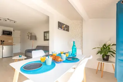 a white table with plates of food on it in a living room at La Maisonnette Narbonnaise (Proche Grands Buffets) in Narbonne