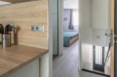 a kitchen with a door open to a bedroom at La Maisonnette Narbonnaise (Proche Grands Buffets) in Narbonne