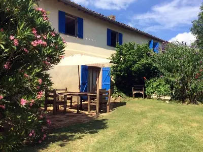 a house with a table and an umbrella in the yard at Belrepayre in Manses