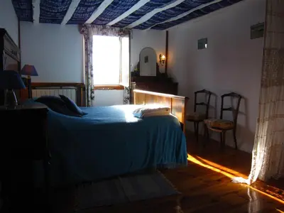 a bedroom with a bed with a blue blanket and a window at Belrepayre in Manses