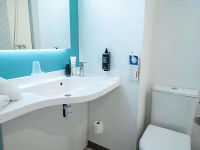 a bathroom with a toilet and a sink and a shower at ibis budget Narbonne Est in Narbonne