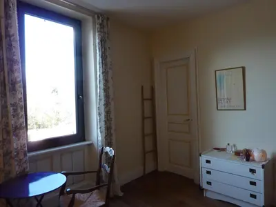 a room with a window and a table and a dresser at les camélias in Mazamet