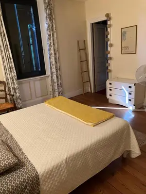 a bedroom with a bed with a yellow blanket on it at les camélias in Mazamet