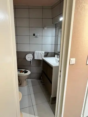 a bathroom with a toilet and a sink at Hôtel Restaurant Les Arcades in Limoux