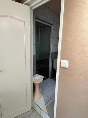 a bathroom with a toilet in a room at Hôtel Restaurant Les Arcades in Limoux