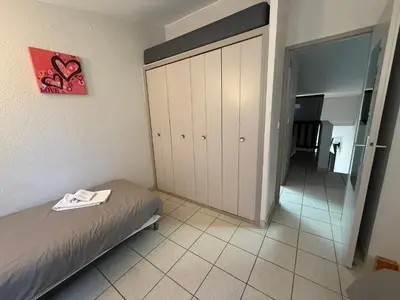 a bedroom with a white bed and two chairs at Le Moulin de Sournia in Sournia