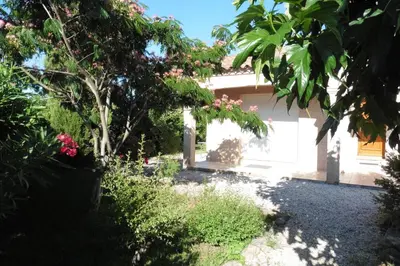 a garden in front of a house with pink flowers at Escapade Audoise in Sallèles-dʼAude