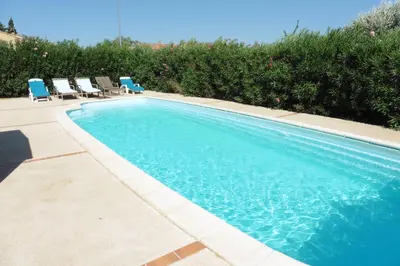a swimming pool with chairs and a swimming pool at Escapade Audoise in Sallèles-dʼAude
