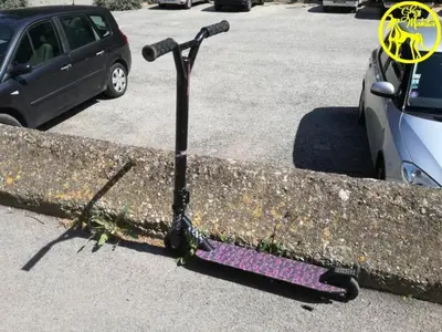 a purple scooter sitting on the side of a parking lot at Chez Makita - RdC in Mirepeisset