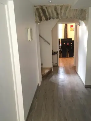 a hallway with a room with white walls and wood floors at Côté chateau in Carcassonne