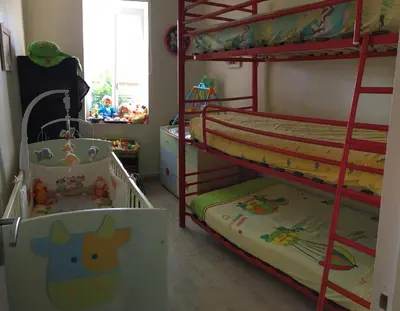 a bedroom with two bunk beds and a crib at Côté chateau in Carcassonne