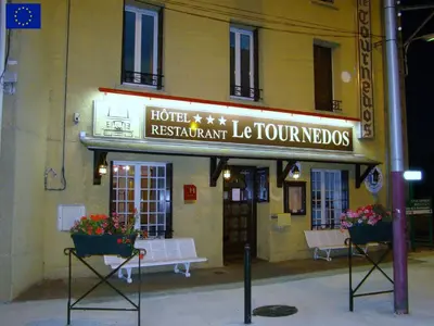 a hotel with two benches in front of a building at Le Tournedos in Lézignan-Corbières