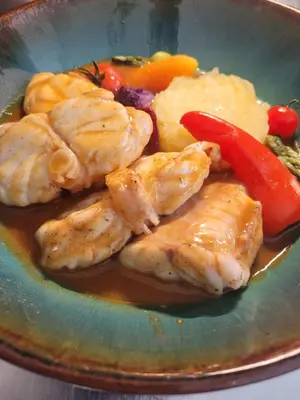 a plate of food with chicken and vegetables and sauce at Le Tournedos in Lézignan-Corbières