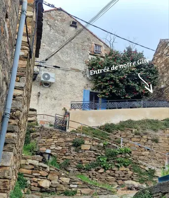 a stone stairway with a sign on a building at Le camélia de la mazarié in Saint-Vincent