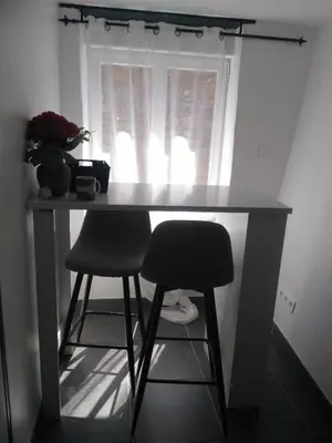 a desk with two chairs in front of a window at Le camélia de la mazarié in Saint-Vincent