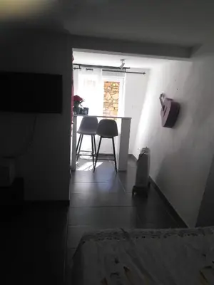 a dark room with a table and chairs in a room at Le camélia de la mazarié in Saint-Vincent