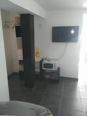 a living room with a tv on the wall at Le camélia de la mazarié in Saint-Vincent