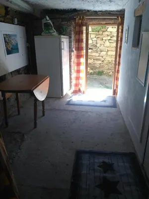 a hallway with a door open to a room with a table at Le camélia de la mazarié in Saint-Vincent