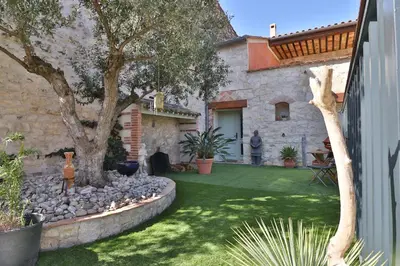 a garden with a tree and a stone house at VILLA ARTEMIA Maison vigneronne - chambre d hôtes-B&B-piscine et spa in Sigean