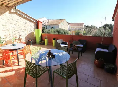a patio with chairs and a table and a table and chairs at VILLA ARTEMIA Maison vigneronne - chambre d hôtes-B&B-piscine et spa in Sigean