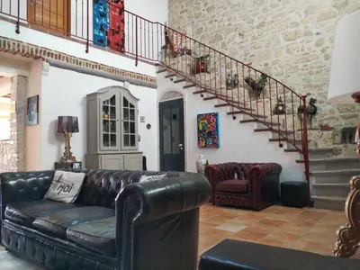 a living room with a leather couch and stairs at VILLA ARTEMIA Maison vigneronne - chambre d hôtes-B&B-piscine et spa in Sigean