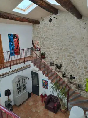 a living room with a staircase and a stone wall at VILLA ARTEMIA Maison vigneronne - chambre d hôtes-B&B-piscine et spa in Sigean