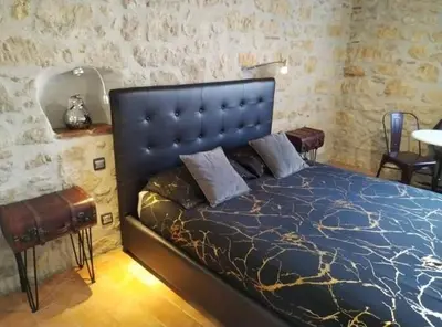 a bedroom with a bed with a blue comforter at VILLA ARTEMIA Maison vigneronne - chambre d hôtes-B&B-piscine et spa in Sigean
