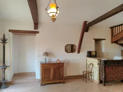 a kitchen with a table and a chair in a room at Grès Vaillant in Saint-Polycarpe