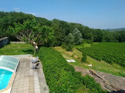 a view of a vineyard with two chairs and a table at Grès Vaillant in Saint-Polycarpe