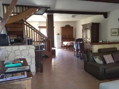 a living room with a couch and a kitchen at Grès Vaillant in Saint-Polycarpe