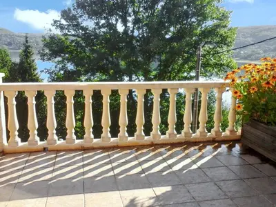 a white railing on a balcony with a tree at Maison chaleureuse à Nages avec vue sur lac et montagne in Nages