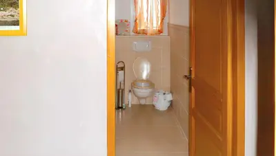 a bathroom with a white toilet in a room at Maison chaleureuse à Nages avec vue sur lac et montagne in Nages