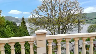 a white fence with a view of the water at Maison chaleureuse à Nages avec vue sur lac et montagne in Nages