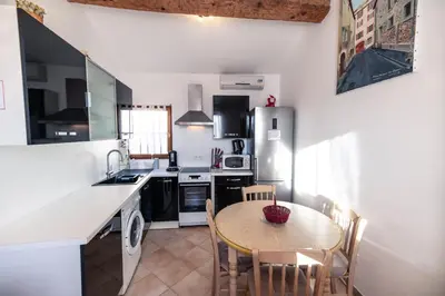 a kitchen with a wooden table and a small table and chairs at Studio du couvent in Narbonne