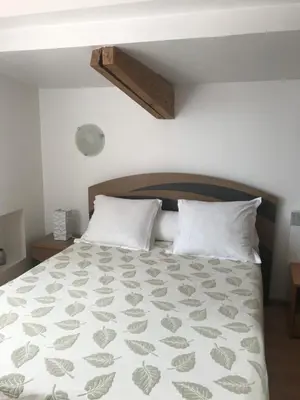 a bedroom with a large bed with white pillows at Studio du couvent in Narbonne