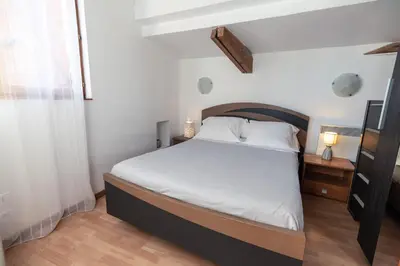 a bedroom with a large bed with white sheets at Studio du couvent in Narbonne